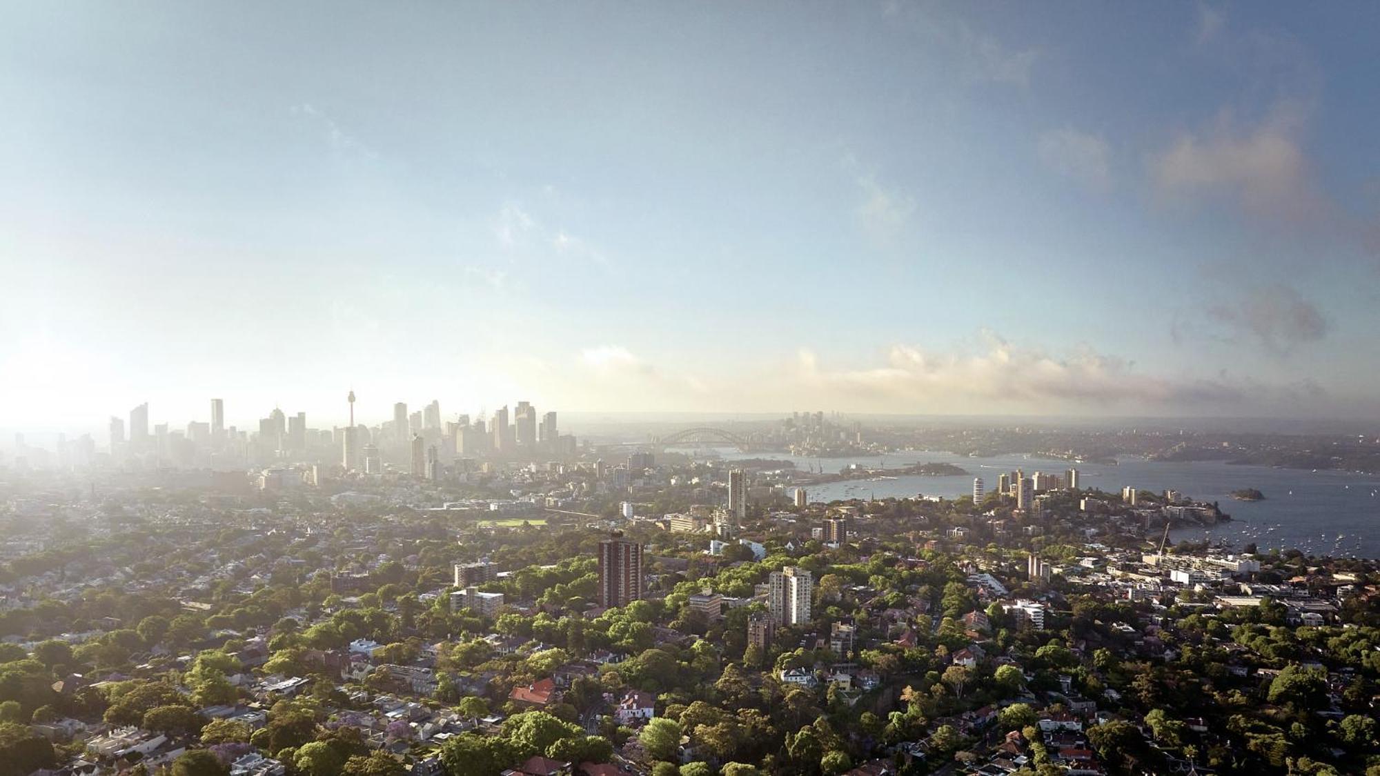 Meriton Suites Bondi Junction Σίδνεϊ Εξωτερικό φωτογραφία The photo shows a panoramic view of a city skyline, likely taken from a high vantage point. In the foreground, there are lush green trees and buildings, suggesting a suburban area. As the view extends towards the background, tall skyscrapers dominate